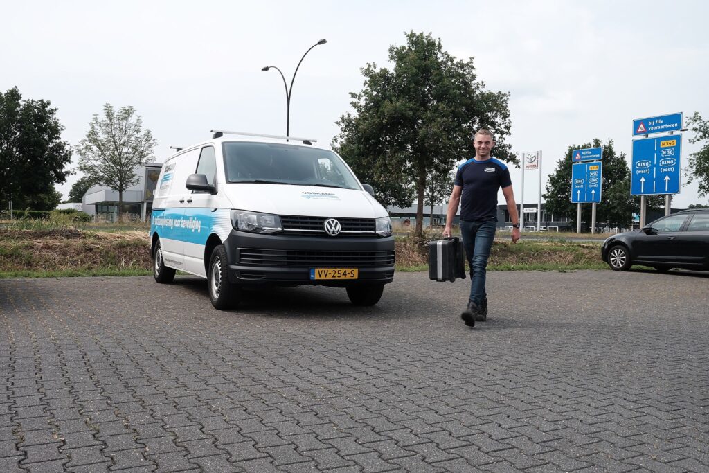 Een medewerker en bedrijfsauto van Voskamp Groep.