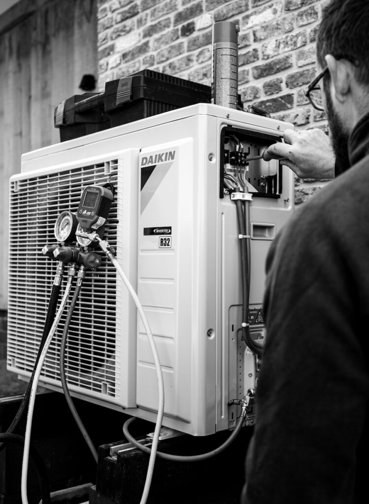 Een installatietechniek monteur bezig bij een airco.